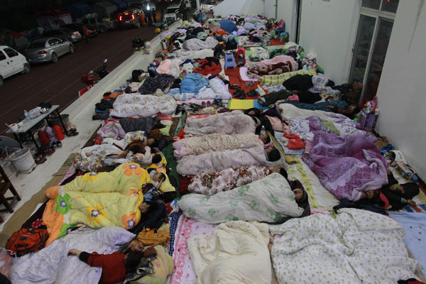 Quake survivors sleep in the open air at a temporary shelter set up at the stadium of Baoxing County New High School on Monday night because the shelter does not have enough tents. Cui Meng / China Daily Death toll reaches 26 in Baoxing